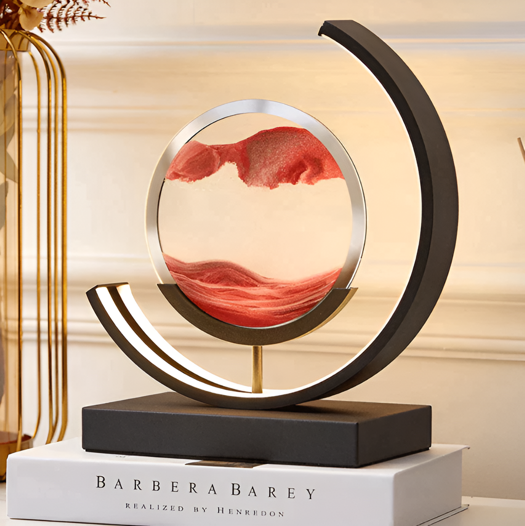 Modern moving sand lamp showcasing layered red sand patterns atop a book decor piece.