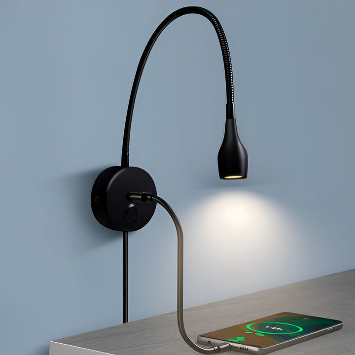Black wall reading lamp charging a smartphone via the integrated USB port on its base