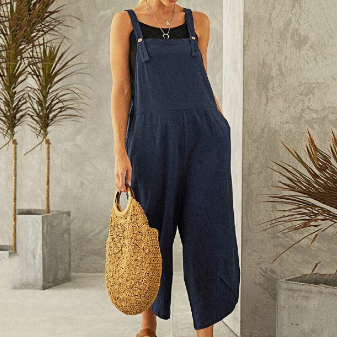 Woman wearing a navy blue wide leg sleeveless jumpsuit with side pockets