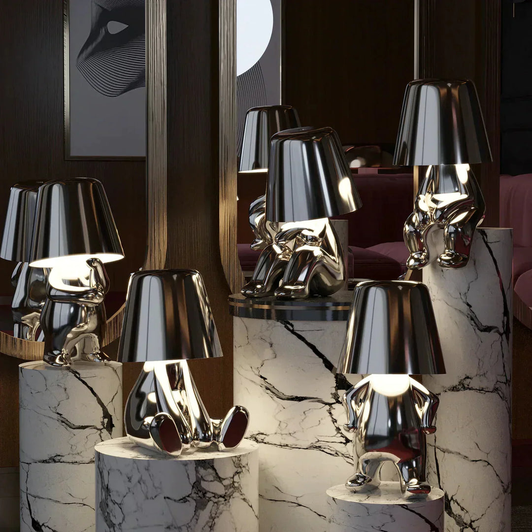 Silver artistic mood lamps glowing on marble pedestals in a luxury interior