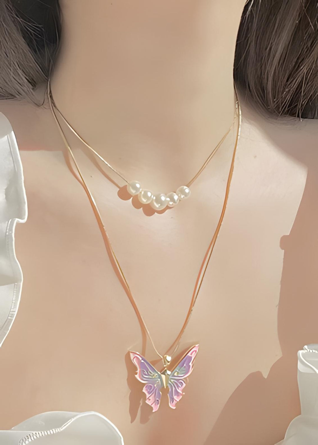 Close-up of the crystal butterfly necklace worn around the neck
