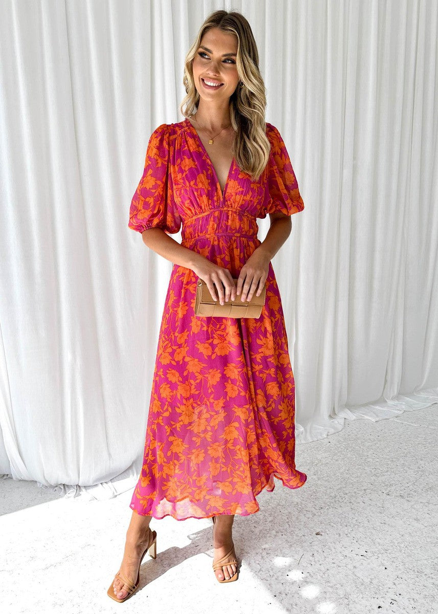 Front view of a woman wearing a pink and orange floral midi dress with puff sleeves