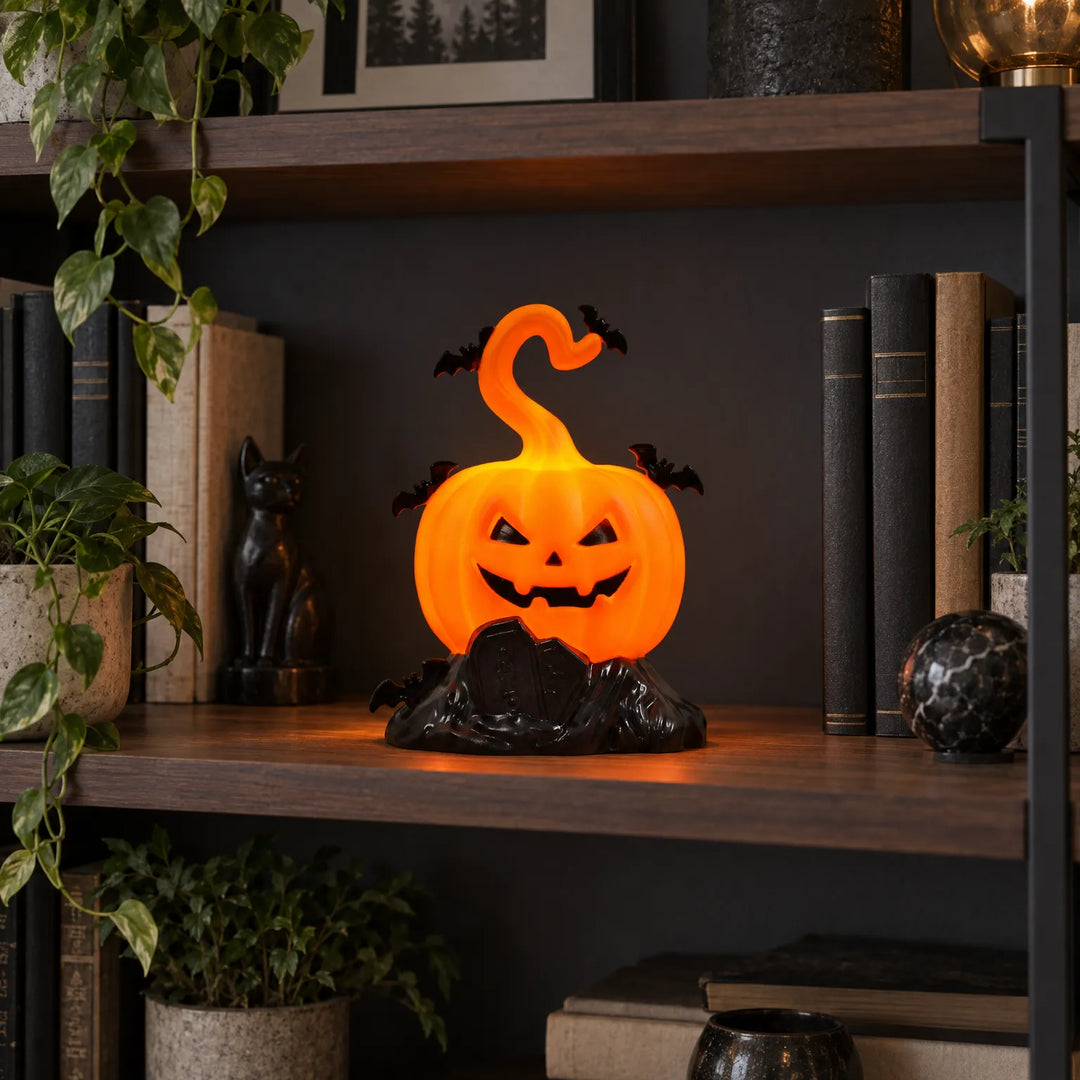 Glowing jack-o-lantern pumpkin decor placed on a bookshelf among books and plants