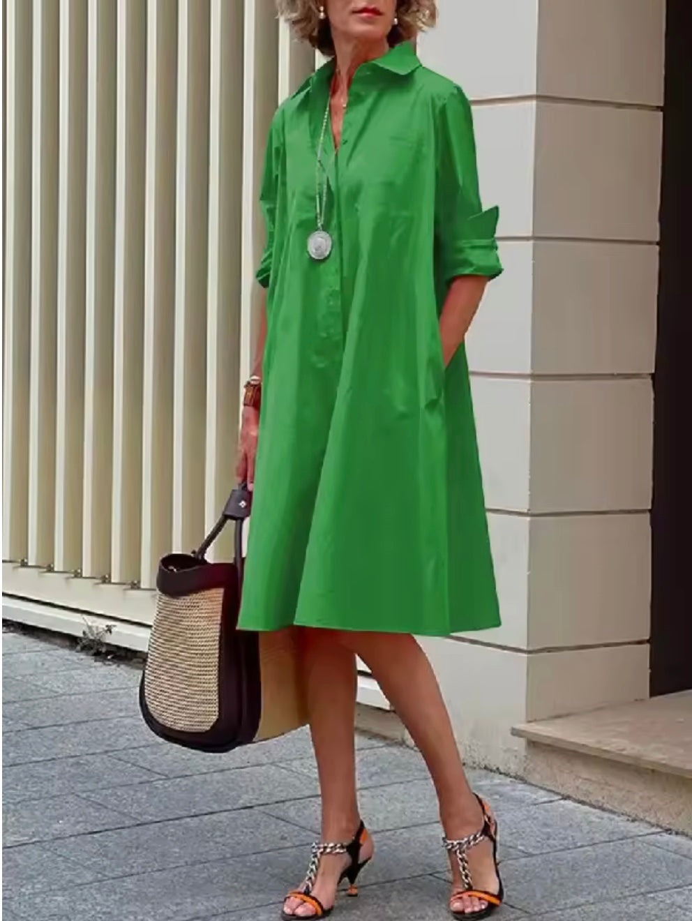 Woman wearing a vibrant green long-sleeve shirt dress with pockets outdoors.