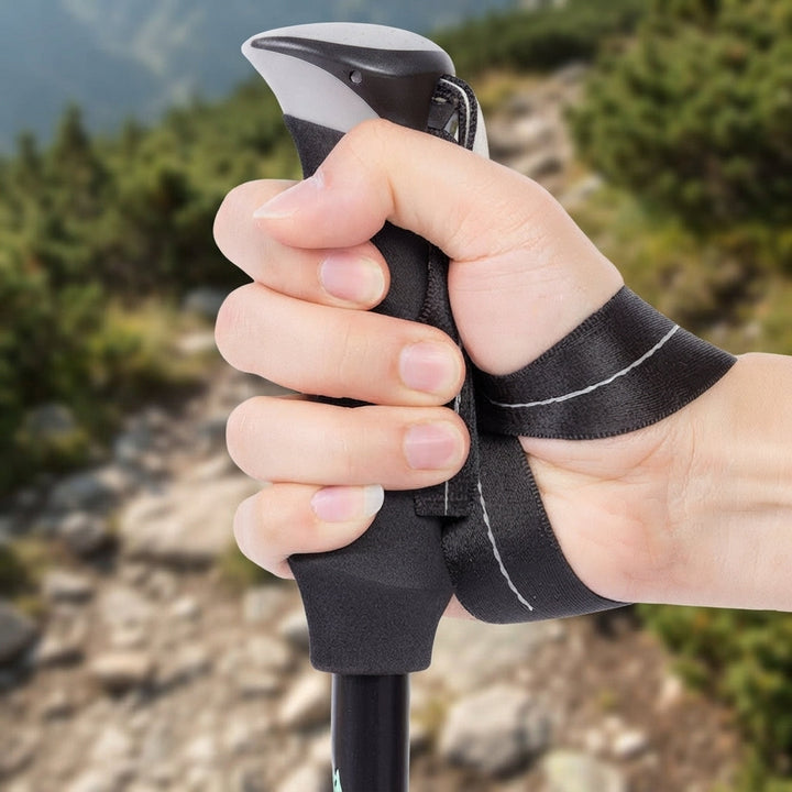 Close-up of ergonomic trekking pole handle grip and wrist strap on hiking trail