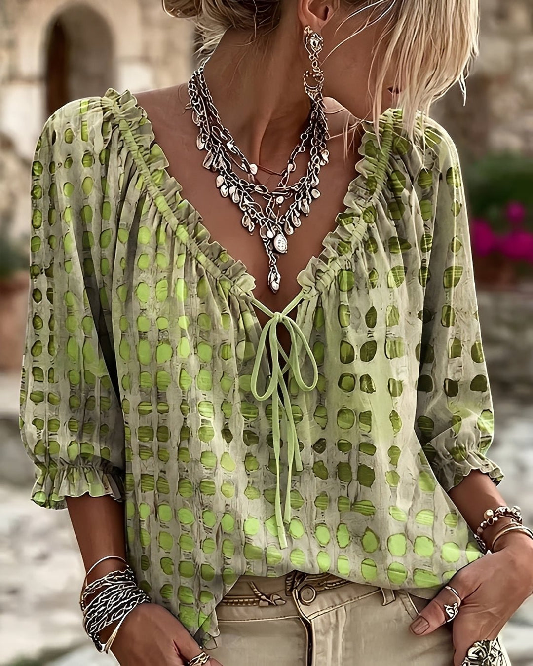 Woman wearing a fresh green polka-dot blouse with three-quarter sleeves