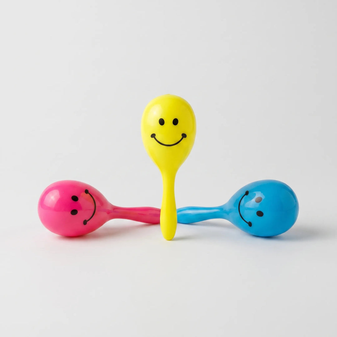 Three colorful smiley face rattle toys for birds displayed on a white background