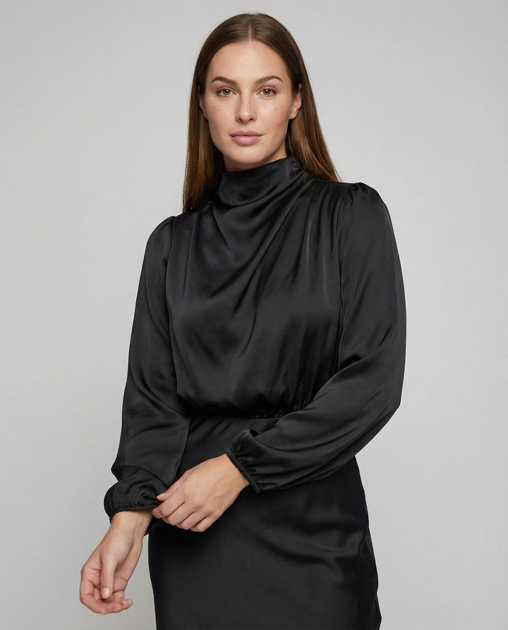 Close-up of model wearing a black long-sleeve dress showing the draped neckline and cuffs