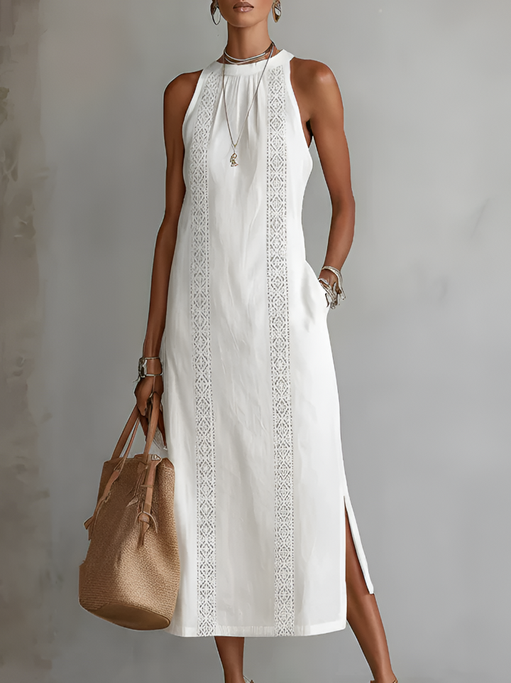 Woman wearing white sleeveless embroidered summer midi dress with handbag