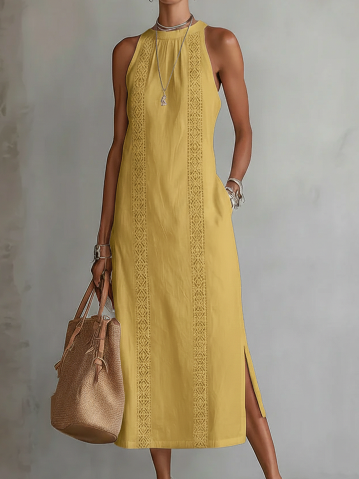 Woman wearing yellow sleeveless embroidered summer midi dress with handbag
