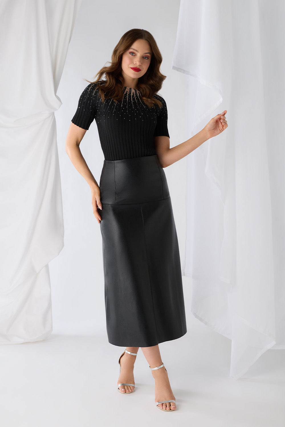 Woman posing in black high waist midi skirt and embellished top