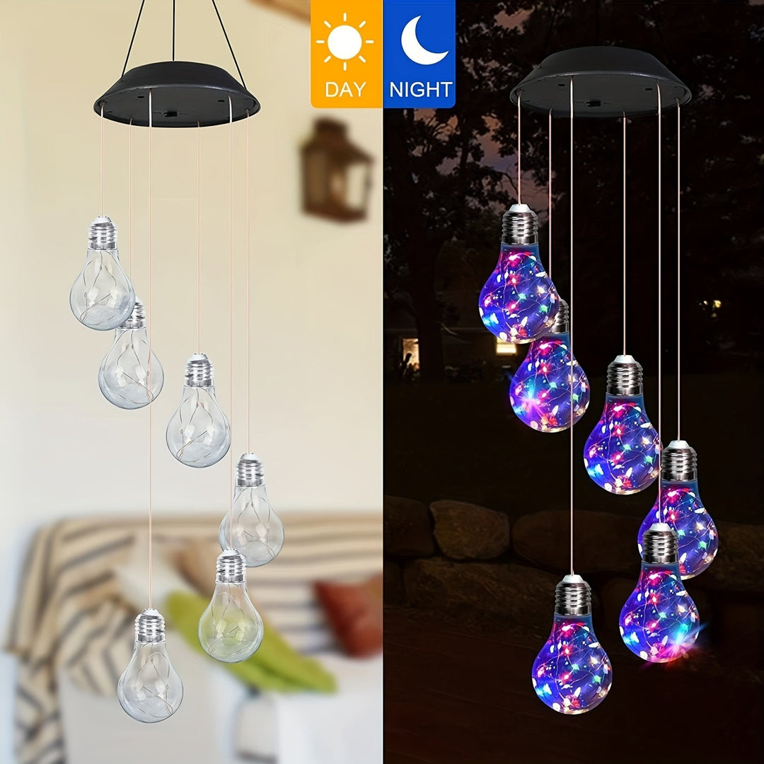 Solar wind chime hanging outdoors with color changing LED lights at night