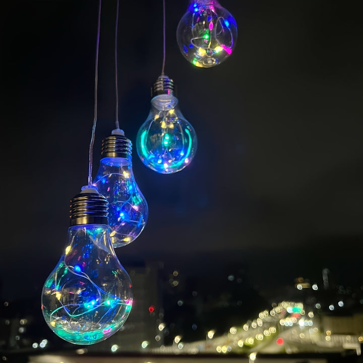 Colorful hanging solar lights illuminating a backyard garden at dusk