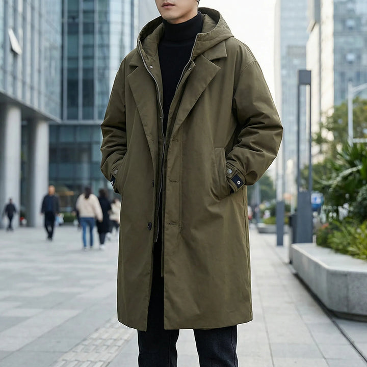 Man wearing a green winter parka trench coat outdoors in the city
