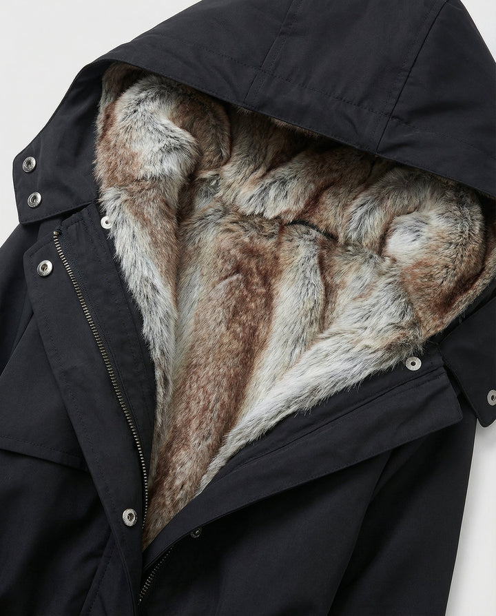 Back view of long hooded winter coat for women, highlighting fashionable padded outerwear silhouette.