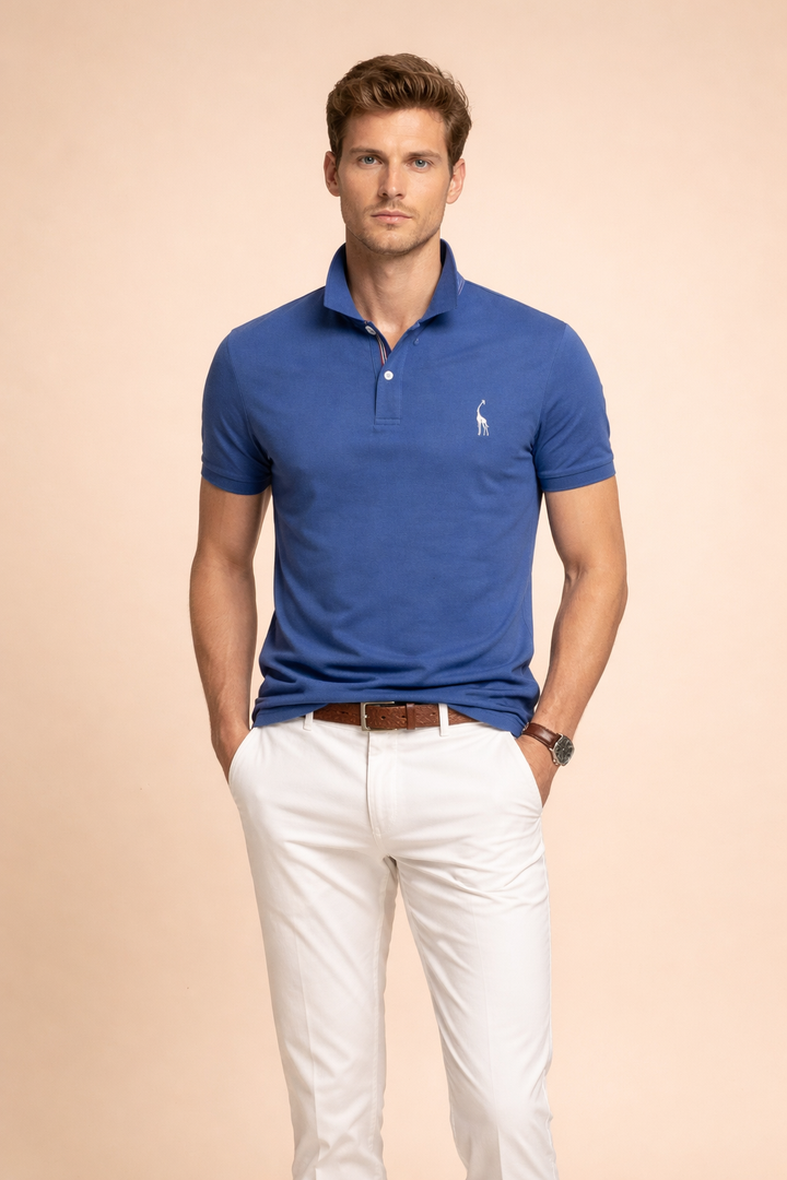Man wearing a blue classic polo shirt paired with white trousers and a brown belt.