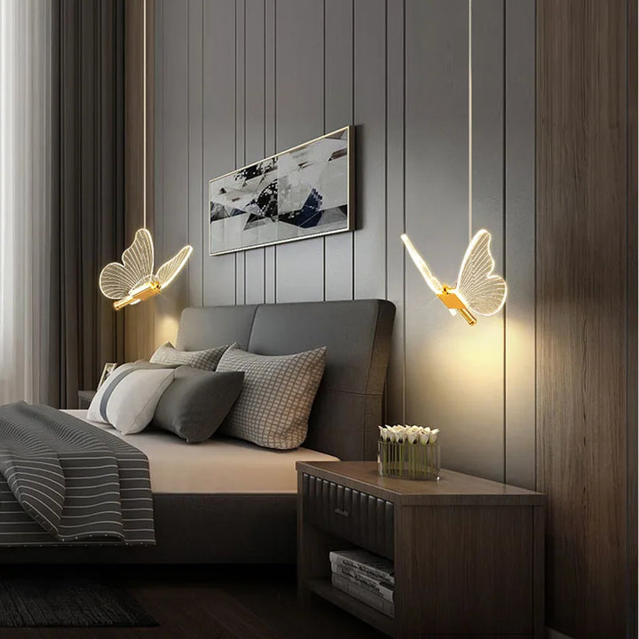 Butterfly pendant lights installed over a bedside table in a bedroom
