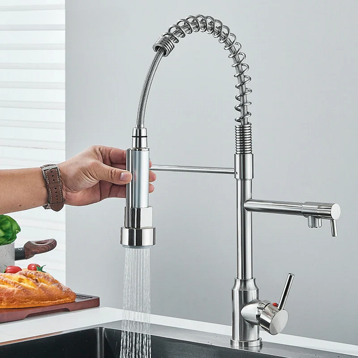 Close-up of a modern chrome kitchen faucet with pull-out spray head over a sink