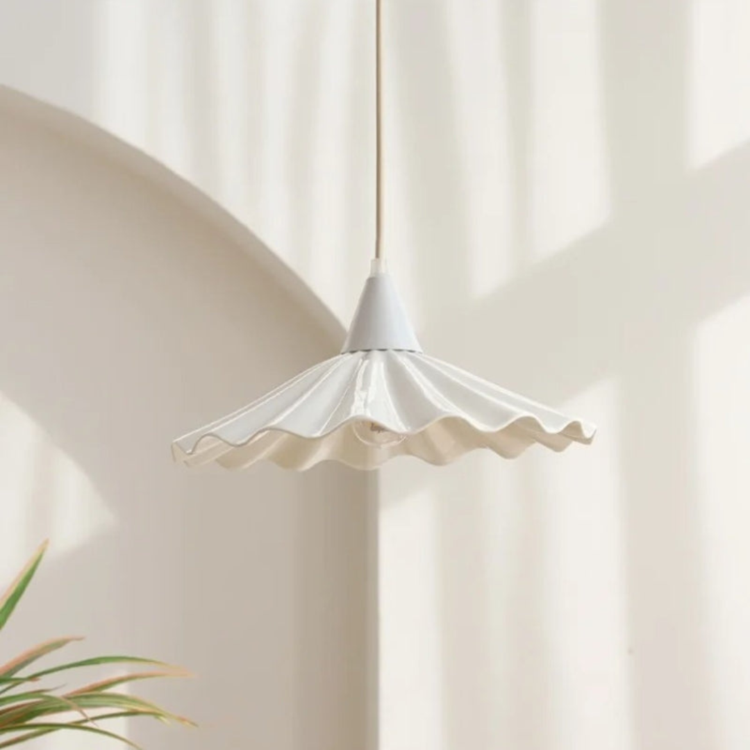 Close-up view of the white ribbed ceramic lampshade casting a warm glow