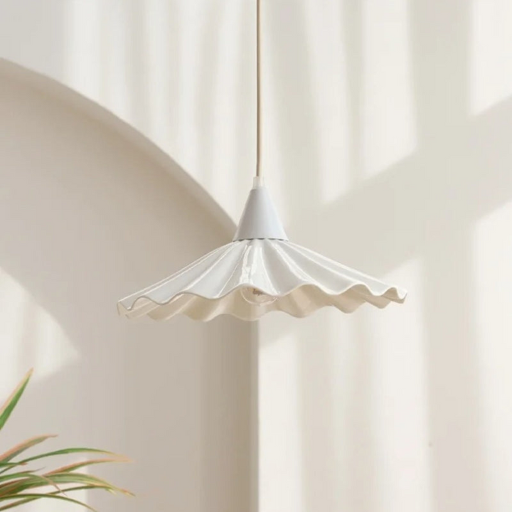 Close-up view of the white ribbed ceramic lampshade casting a warm glow
