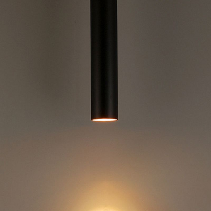 Contemporary cylindrical ceiling light fixture illuminating a stylish living room space.
