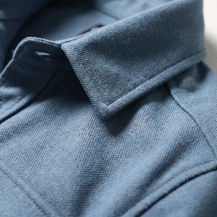 Close-up detail of the collar and textured fabric of the blue overshirt
