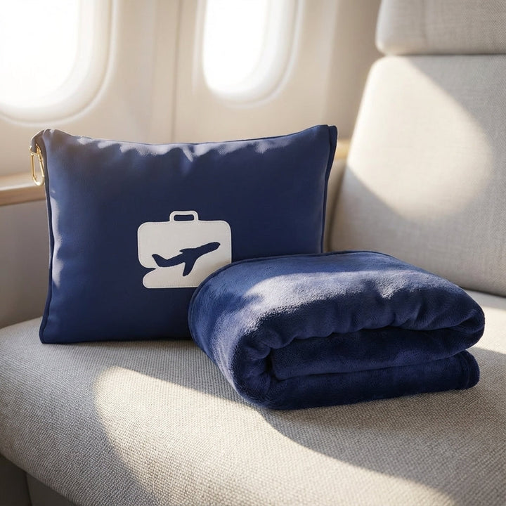 Dark blue travel pillow and folded blanket set inside an airplane cabin