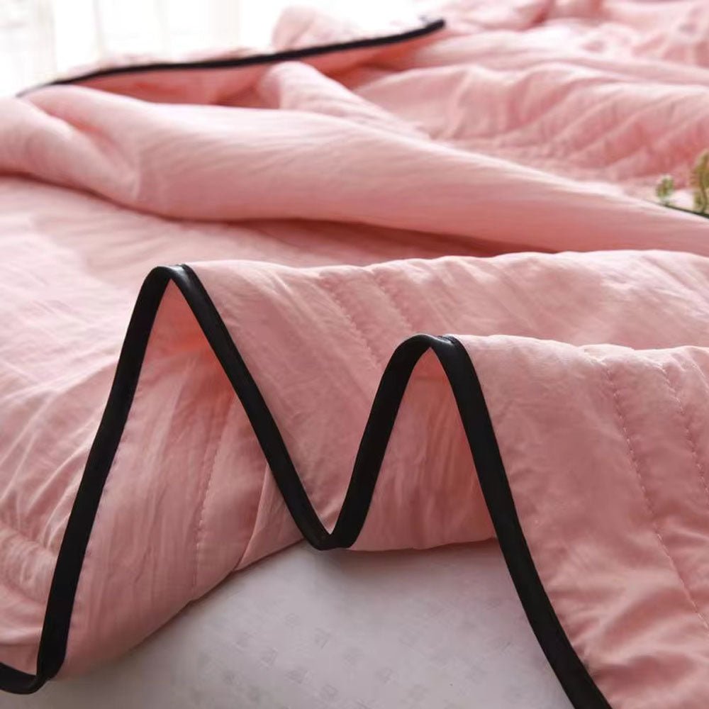 Lightweight textured cooling blanket folded neatly on a modern wooden chair