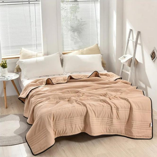 Breathable summer blanket draped casually over a cozy living room couch