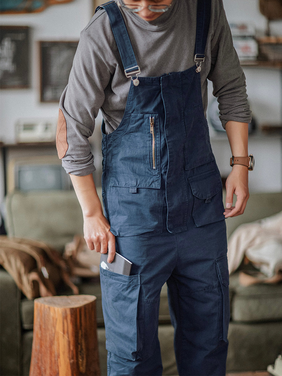 Flat lay of men's clothing featuring utility overalls and accessories