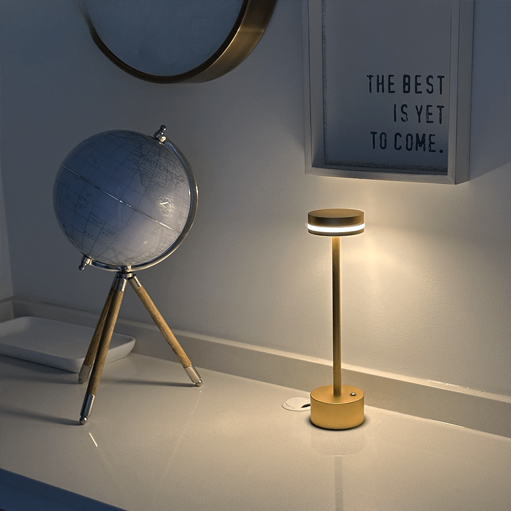 Rechargeable wireless lamp casting warm LED light across a stylish bedroom desk