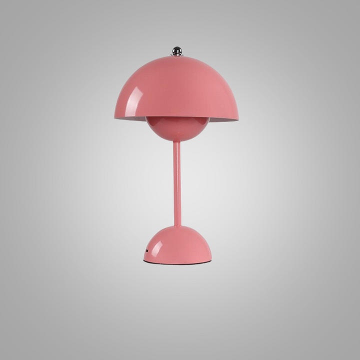 Portable battery-operated table lamp casting warm glow on a wooden surface