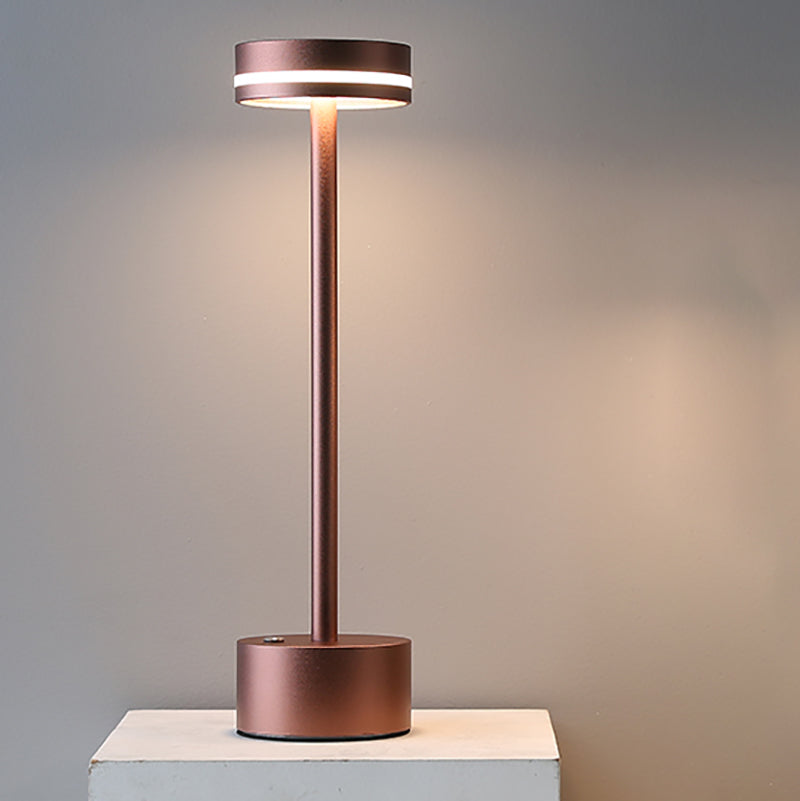 Minimalist cordless table lamp glowing softly in a cozy study