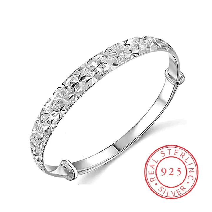 Studio product view of the polished silver star bangle with adjustable closure