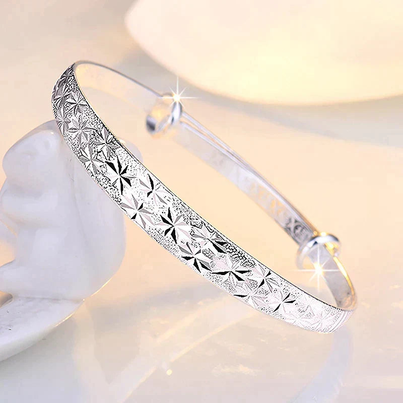 Silver star bangle bracelet worn on a wrist as stylish everyday accessories for women