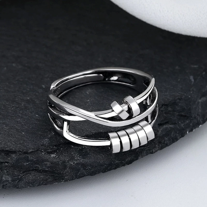 Close-up shot of the minimalist silver spinner ring resting on a dark display stone.