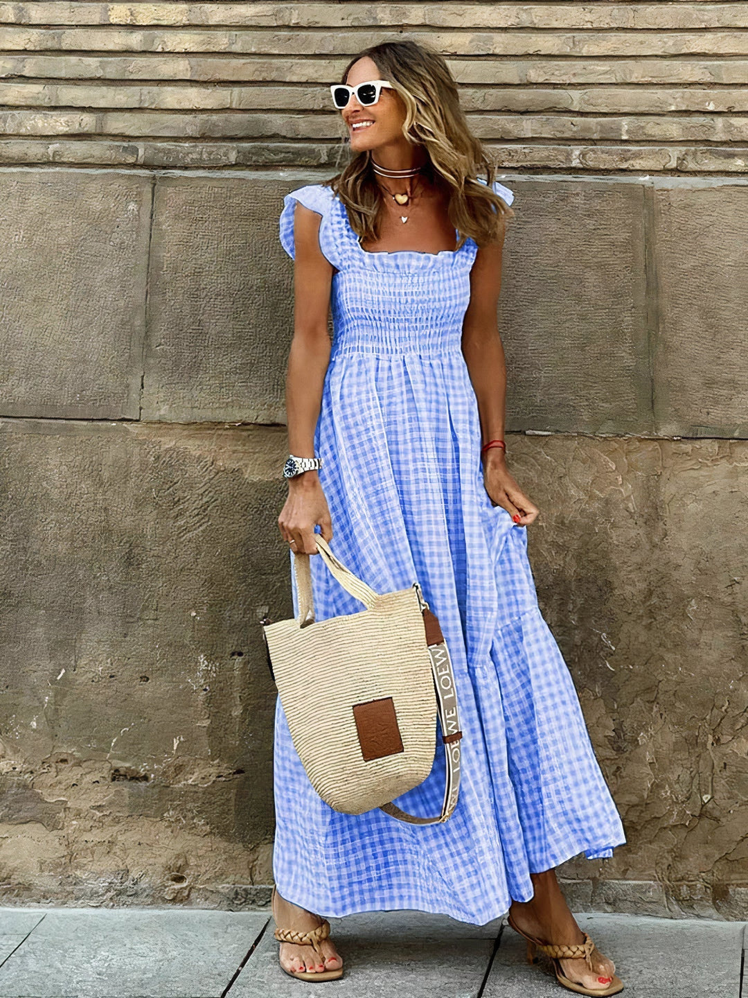 Woman showcasing blue plaid maxi dress with ruffled shoulders