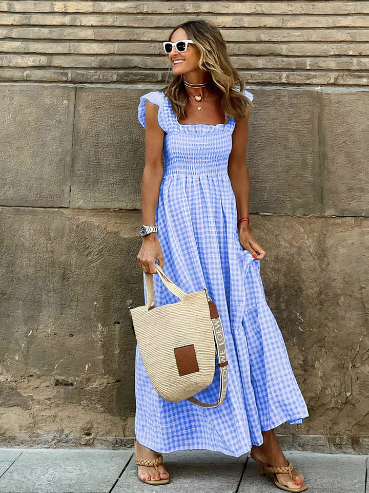 Woman showcasing blue plaid maxi dress with ruffled shoulders