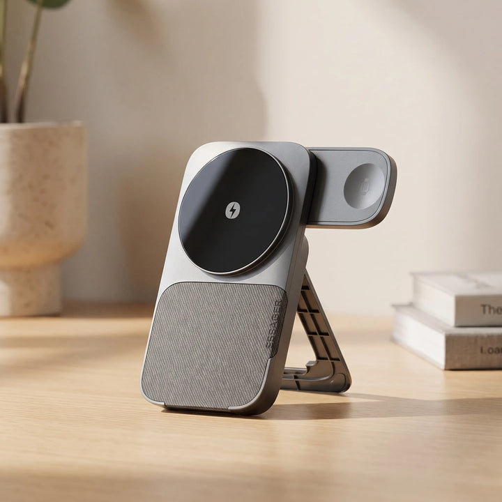 Magnetic wireless charger stand placed on a wooden desk next to a potted plant