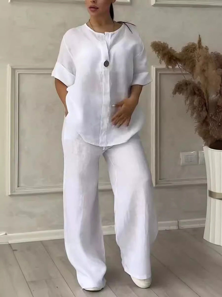 Model wearing white two-piece lounge set with relaxed fit top and trousers