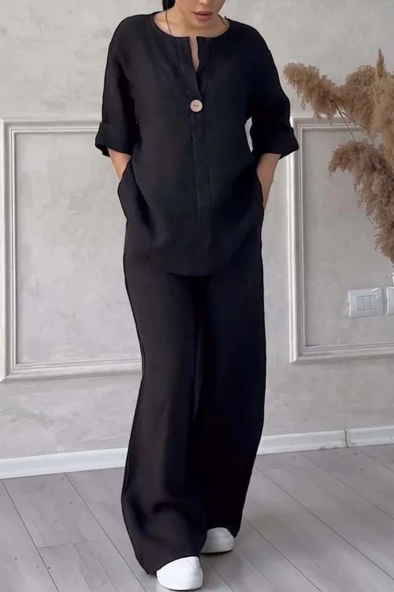 Model wearing black two-piece lounge set showcasing button detail