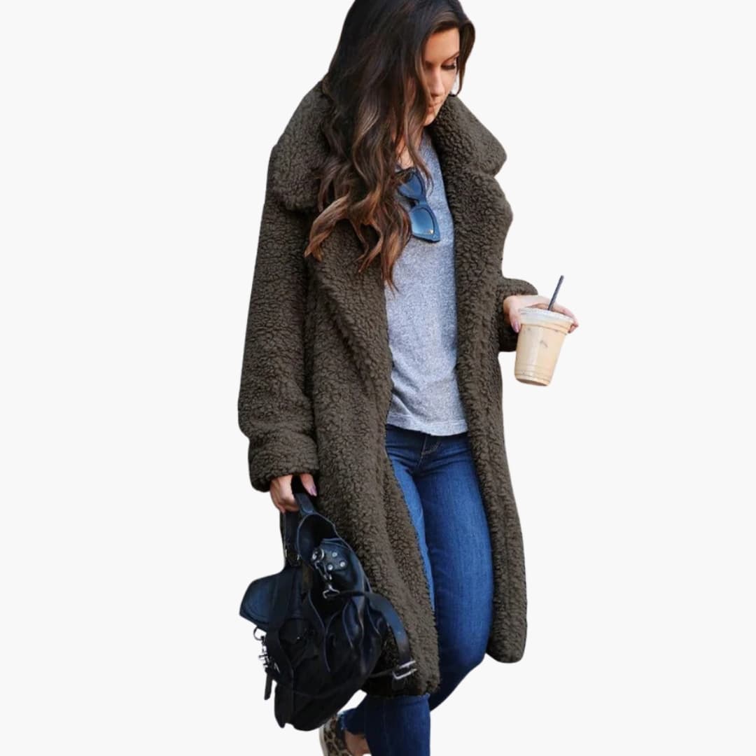 Woman wearing dark green long teddy coat outdoors with coffee cup