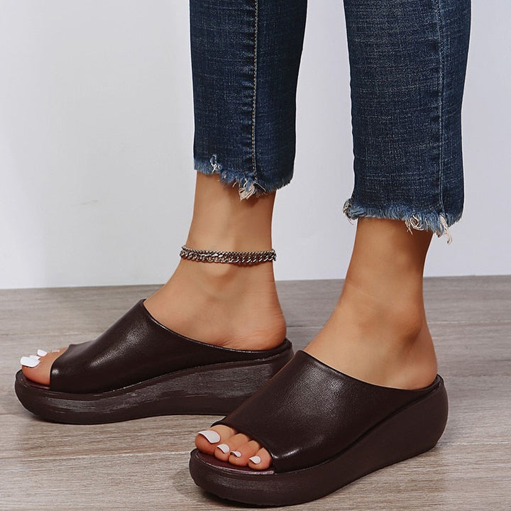 Close-up view of brown ergonomic comfort slippers on feet