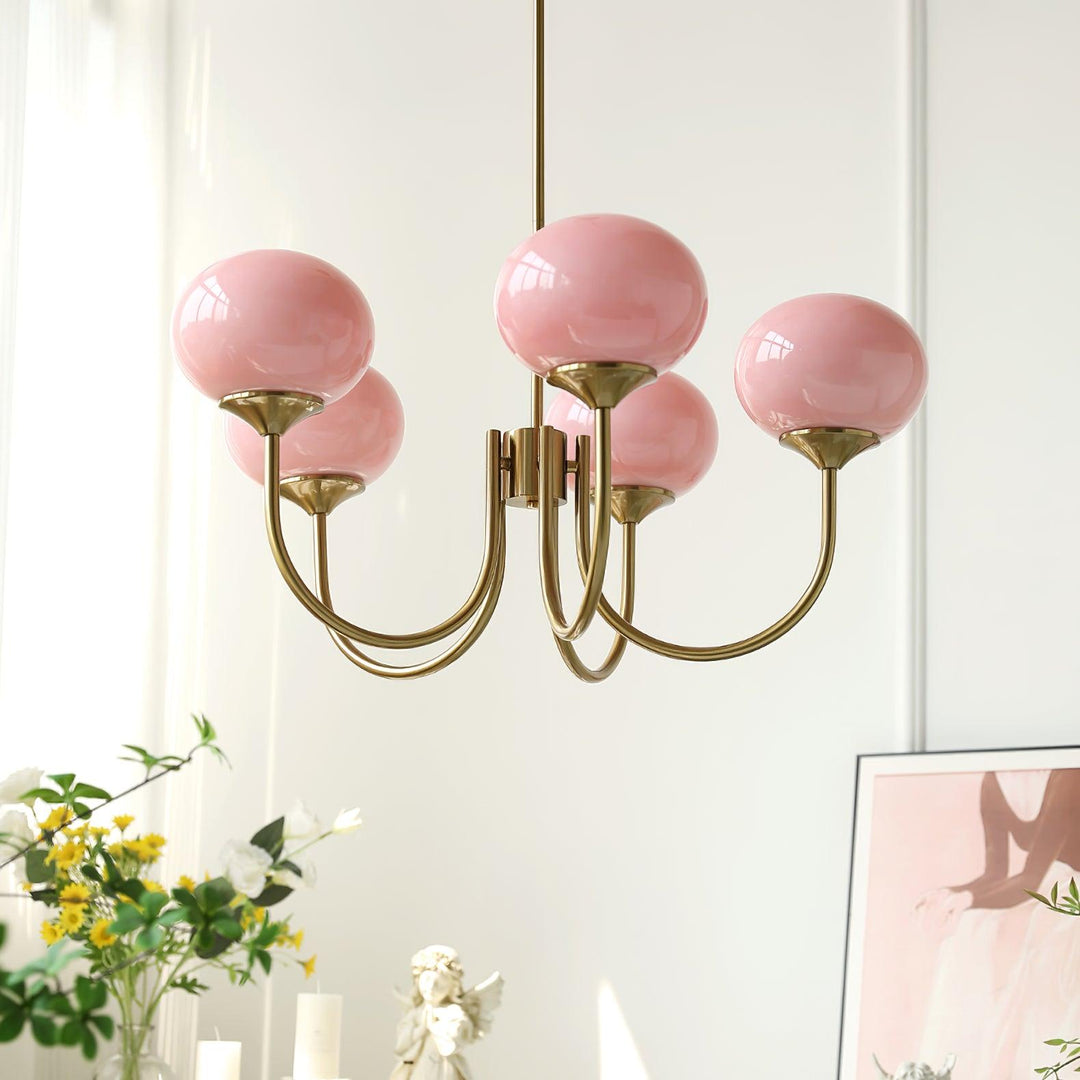 Close-up of a pink glass sphere chandelier with brass arms