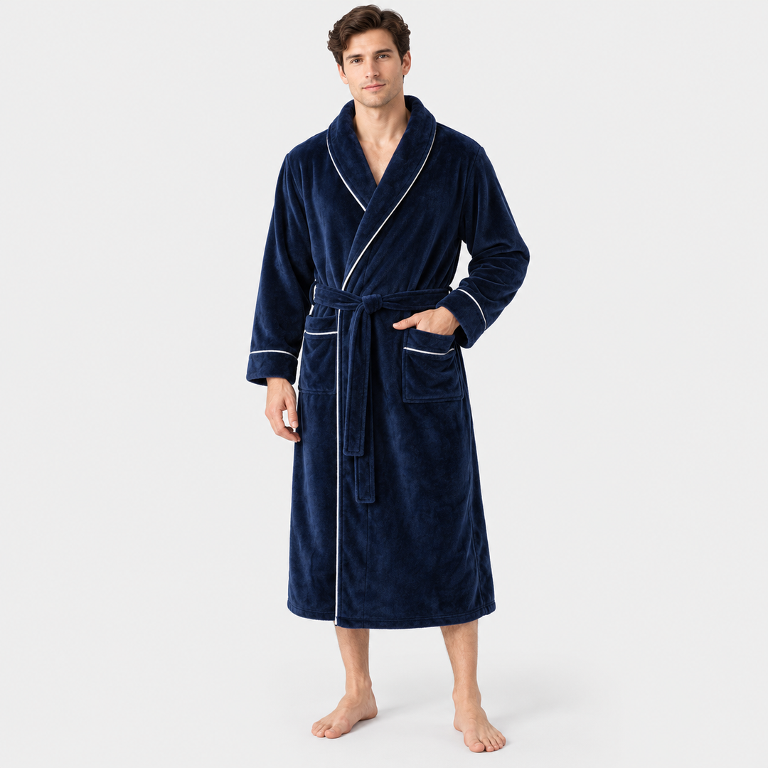 Man showcasing a navy blue long hooded bathrobe in a bright room
