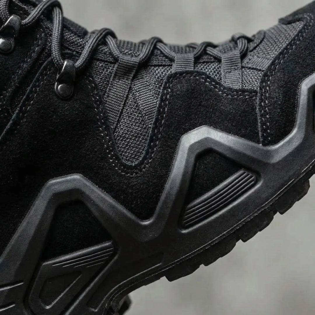 Close-up detail of reinforced upper and thick treaded sole on black boots