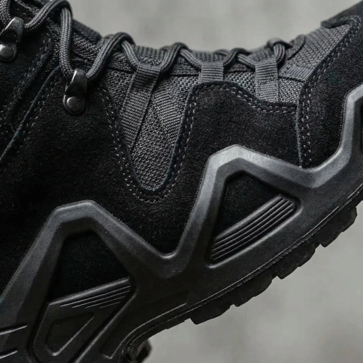 Close-up detail of reinforced upper and thick treaded sole on black boots
