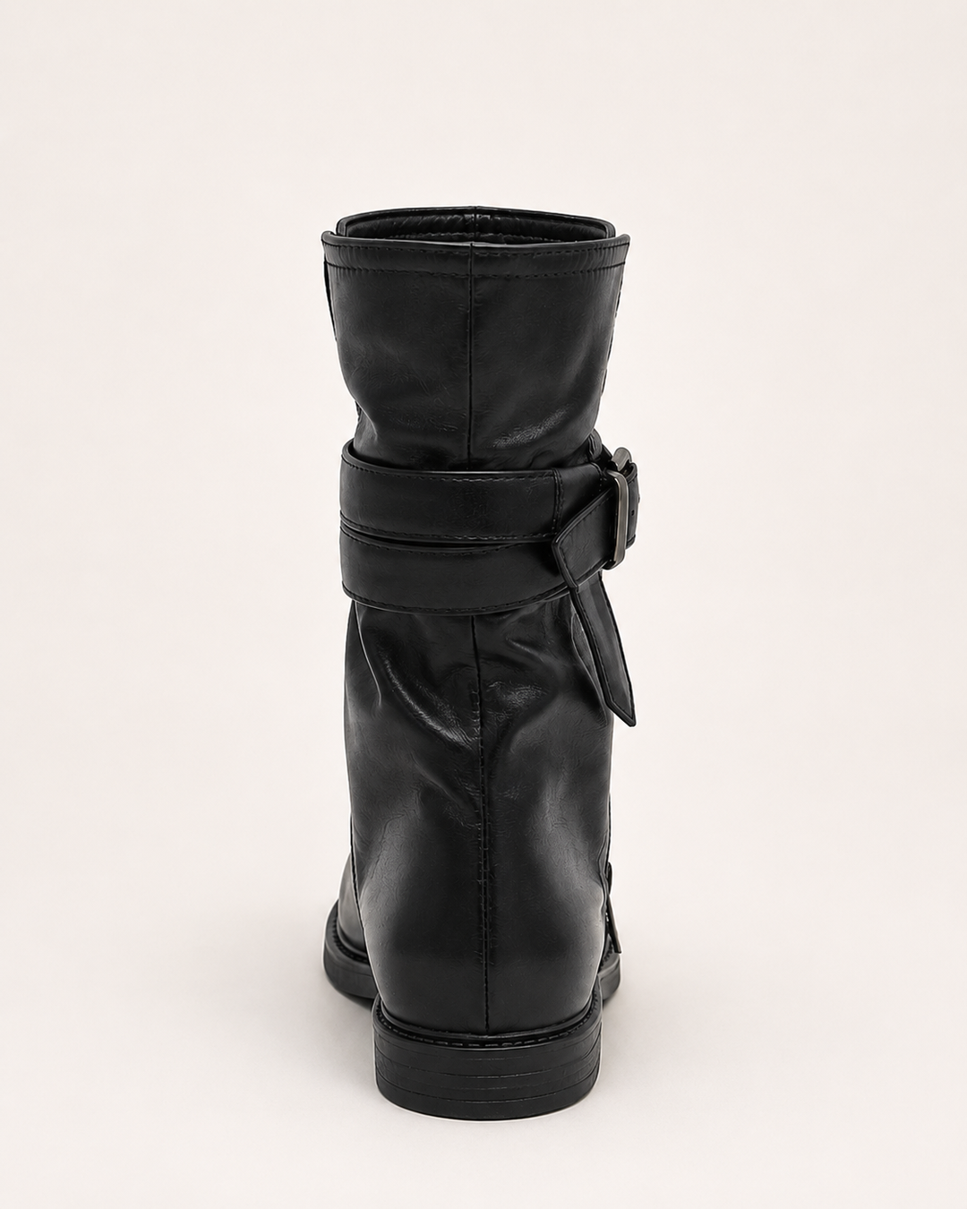 Close-up of black boots for women showcasing decorative metal buckles and durable biker boot tread.