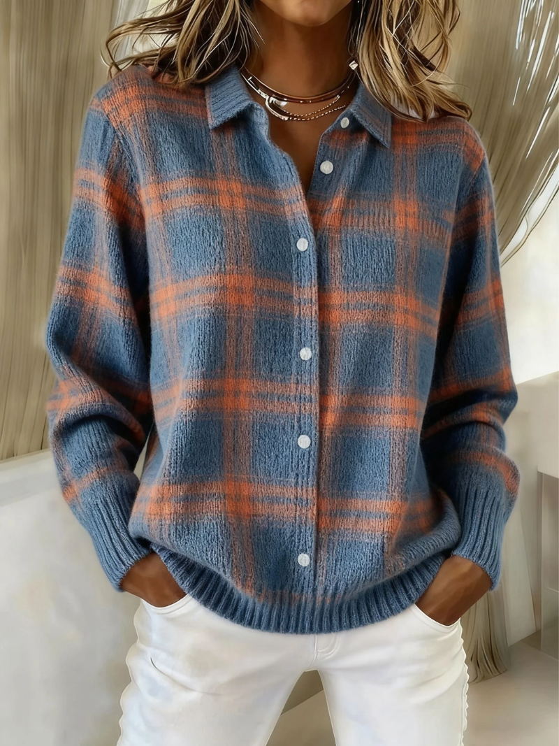 Woman wearing a blue and orange check patterned knitted button-up blouse with white trousers