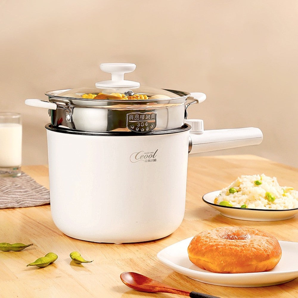 Electric cooking pot assembled with the stainless steel steamer insert on top, filled with food.